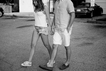 a couple in shorts walking holding hands 
