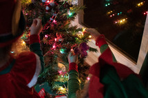 kids decorating a Christmas tree