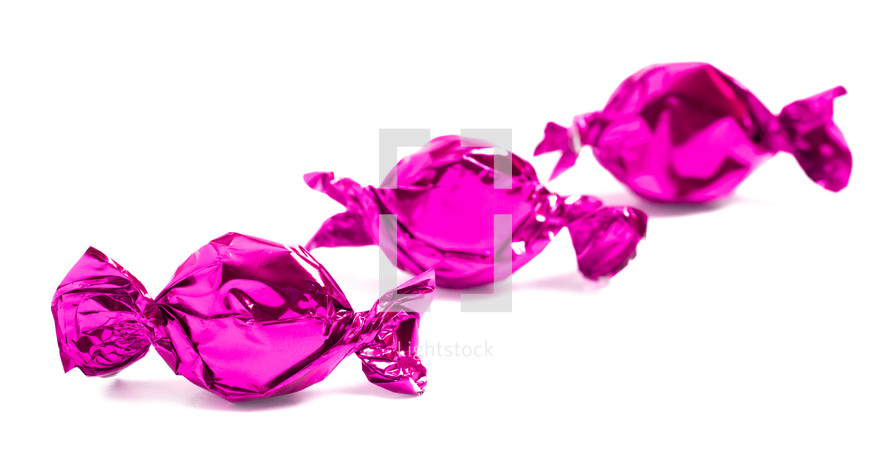 pink wrapped candies on a white background 