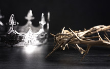 crown of thorns and crown on a wooden background 