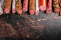 Assortment of various aromatic salami sausages. Against a dark background. High quality photo