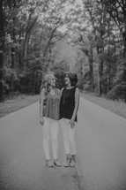 mother and daughter standing in the middle of a rural road 