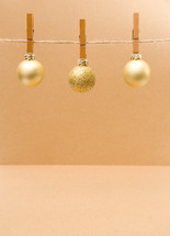 gold ornaments hanging from clothespins 