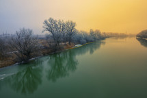 Beautiful winter sunrise and fog on Siret river
