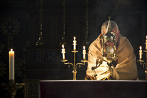 priest in prayer at the altar 