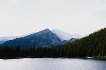A lake surrounded by pine trees and mountains.