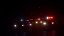 a line of police cars with flashing lights at night 