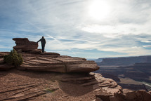 man standing at the top of a mountain 