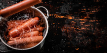 Delicious sausages boiled on the table. On a black background. High quality photo