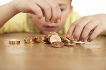 a boy child counting gold coins 