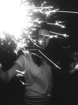 a girl holding a sparkler 