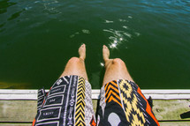 feet in the water hanging over a dock 