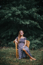 portrait of a teen girl sitting in a wicker chair outdoors 