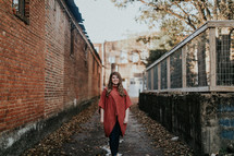 a woman standing in an alley in fall 
