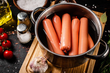 Delicious sausages boiled on the table. On a black background. High quality photo