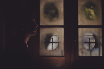 side profile of a man standing in a dark room and frosted windows 