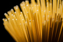 A pile of spaghetti dry on the table. Against a dark background. High quality photo