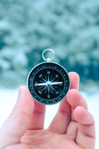 a hand holding up a compass 