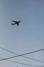 airplane in flight over power lines