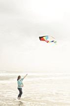 woman flying a kite at the beach