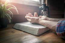 Close up beside of holy Bible with hands praying background