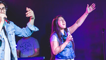 worship leaders singing on stage at a worship service 