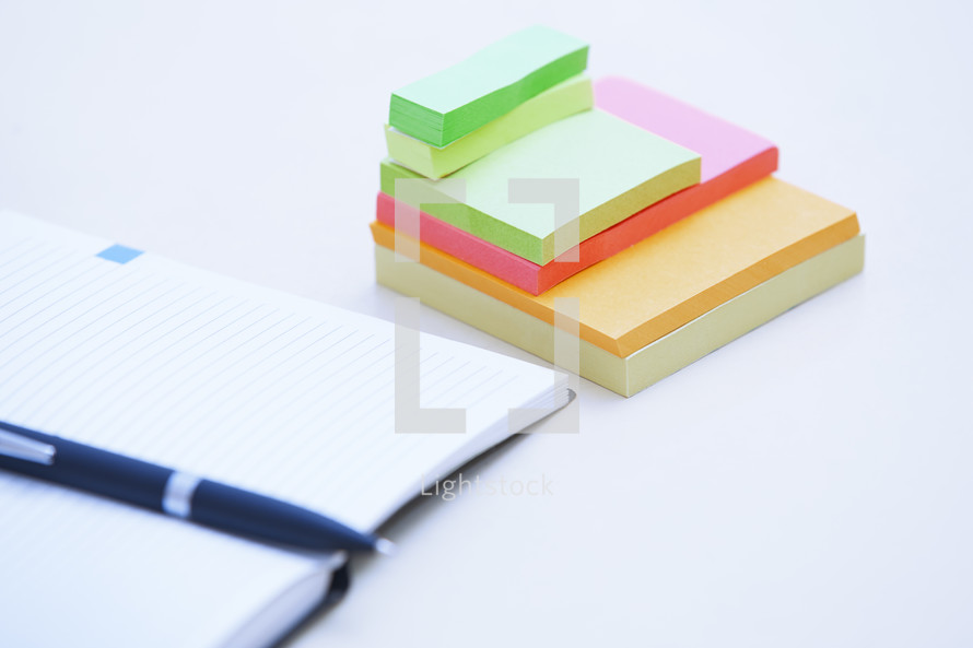 open planner and sticky notes on a desk 