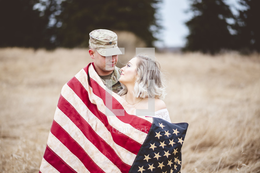 military couple wrapped in an American flag 