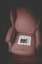 Sonogram image on a Bible open to Psalm 139 in a chair in a dimly lit room.