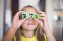 Young girl plays with toy glasses.