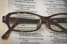 Reading glasses on an open Bible.