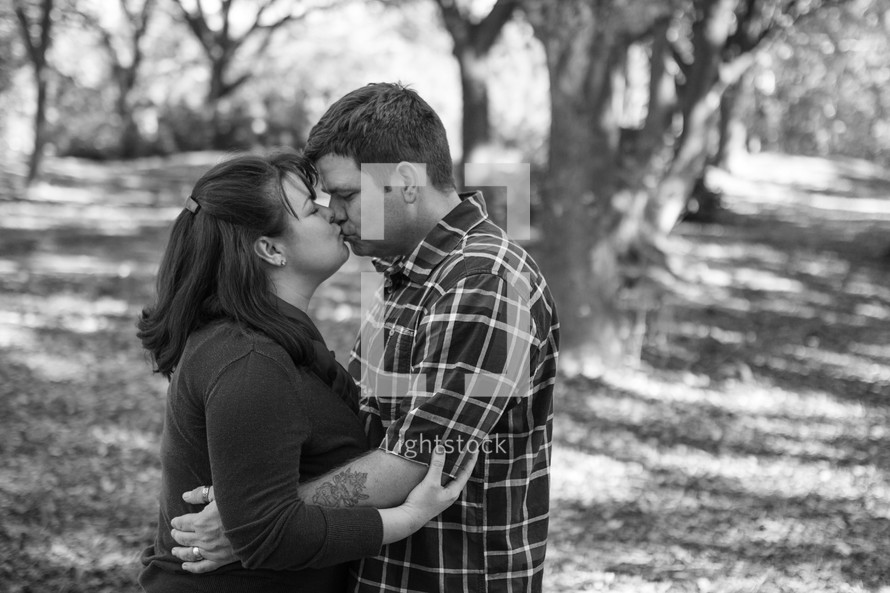 Couple kissing  in a wooded area