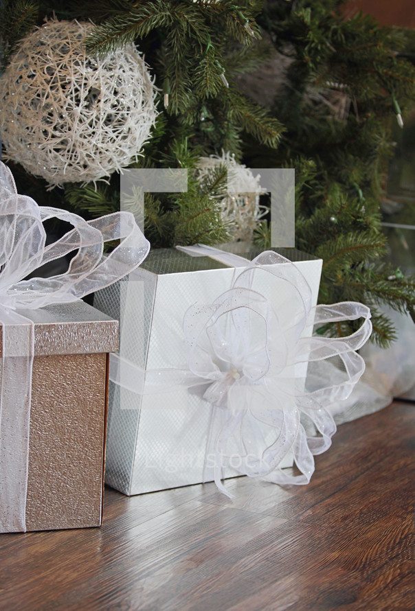 beautifully wrapped white gift under tree