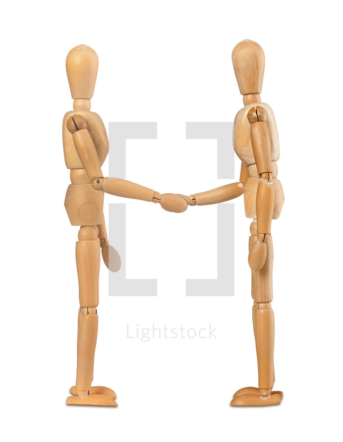 Two wooden dummies shake hands on white background