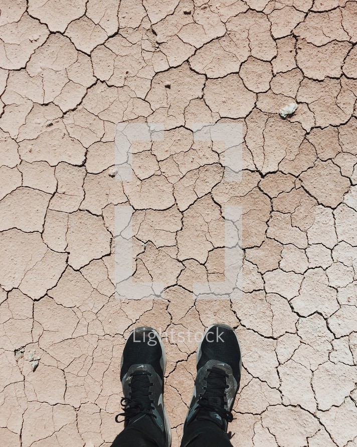 man standing on parched soil 