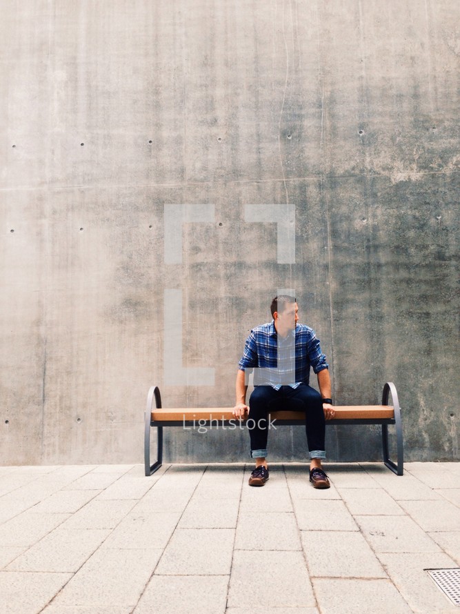 man waiting sitting on a bench 
