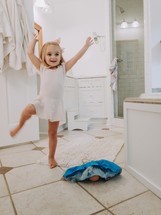 toddler girl dancing in the bathroom as mom gets ready 