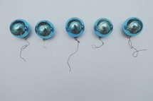 A row of shiny blue vintage ornaments with copy space.