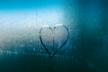 a heart drawn in condensation on a window 