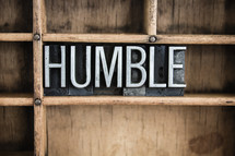 word humble in blocks on a bookshelf 