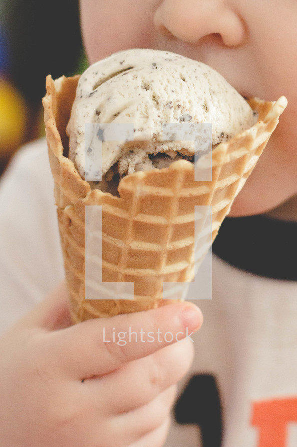 Child eating ice cream cone.