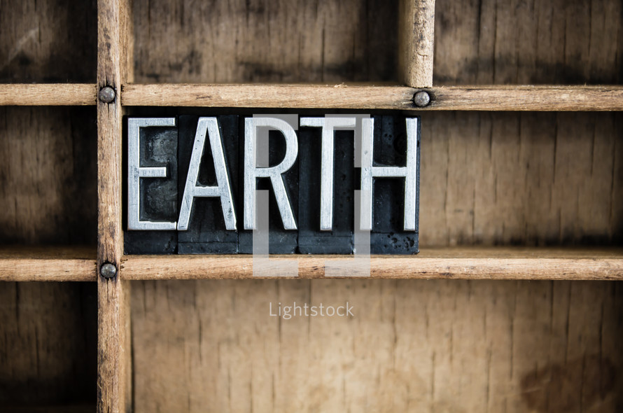 word Earth in blocks on a bookshelf 