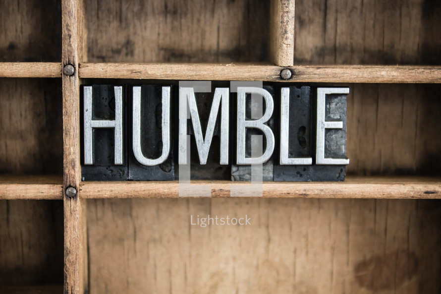 word humble in blocks on a bookshelf 