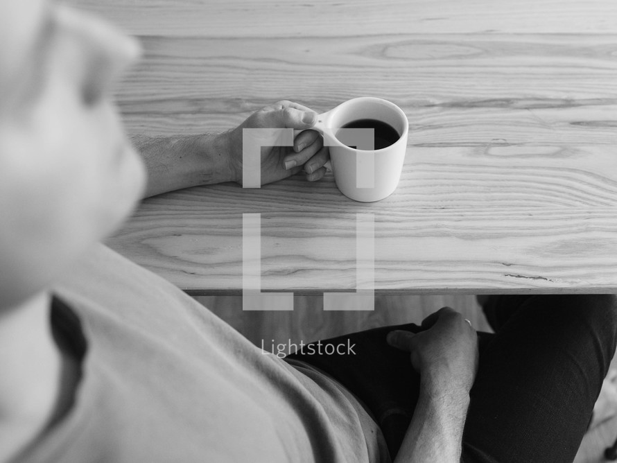 a man sitting with a mug of coffee 