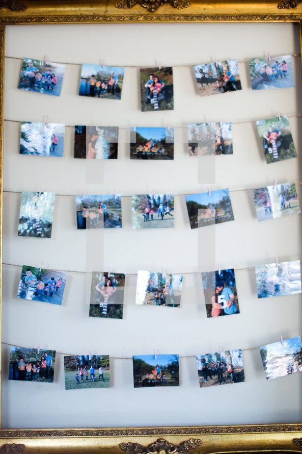 Photographs strung across a frame.