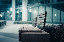 snow on a bench at night 