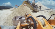 POV shot of a large excavator working in a large construction site.