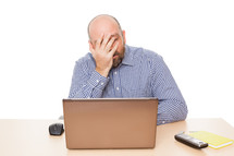 stressed man sitting in front of a computer 