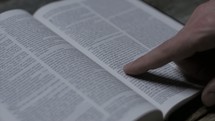 reading a Bible and pointing to scripture 