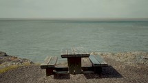 picnic table by a shore 